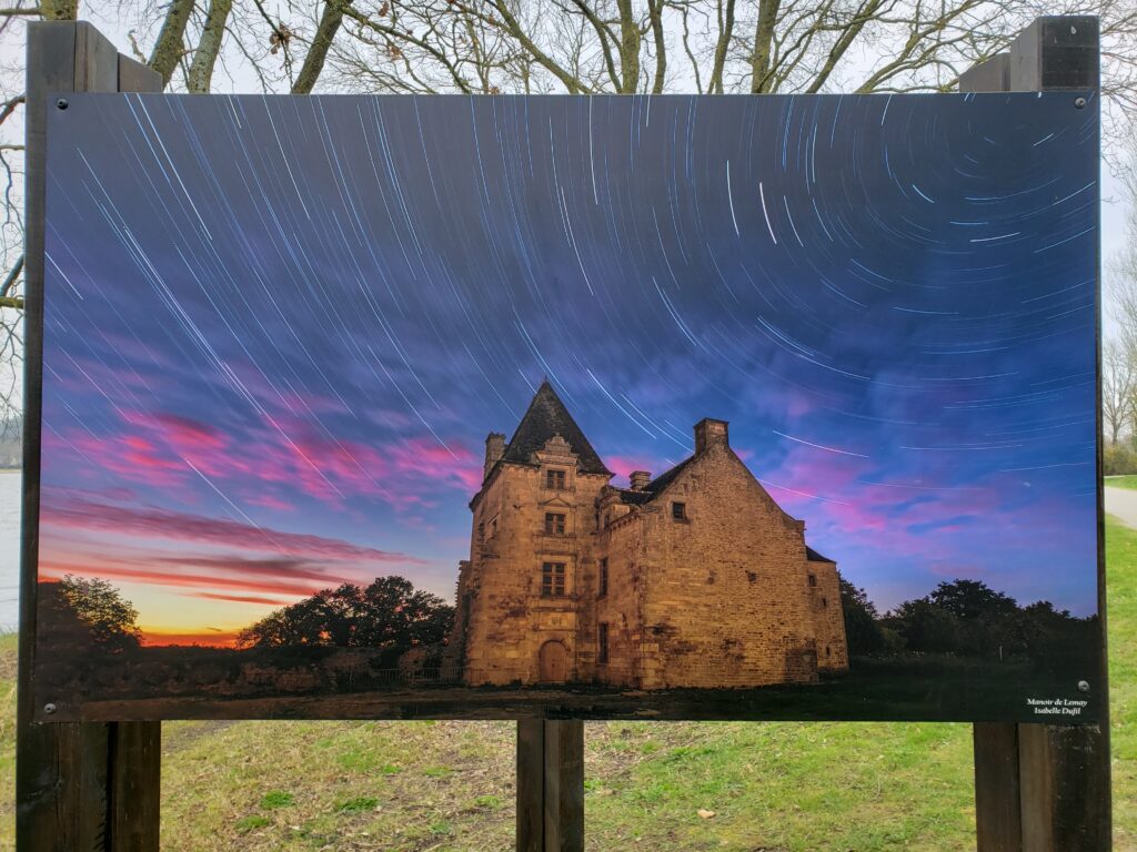 Photographic artwork of an old manor house with stars swirling above in a colorful night sky