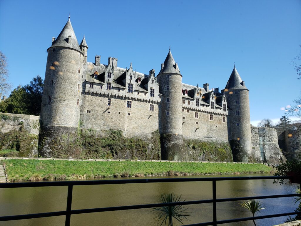 The façade of a French castle with it's high walls towers grandly over the Nantes-to-Brest Canal.