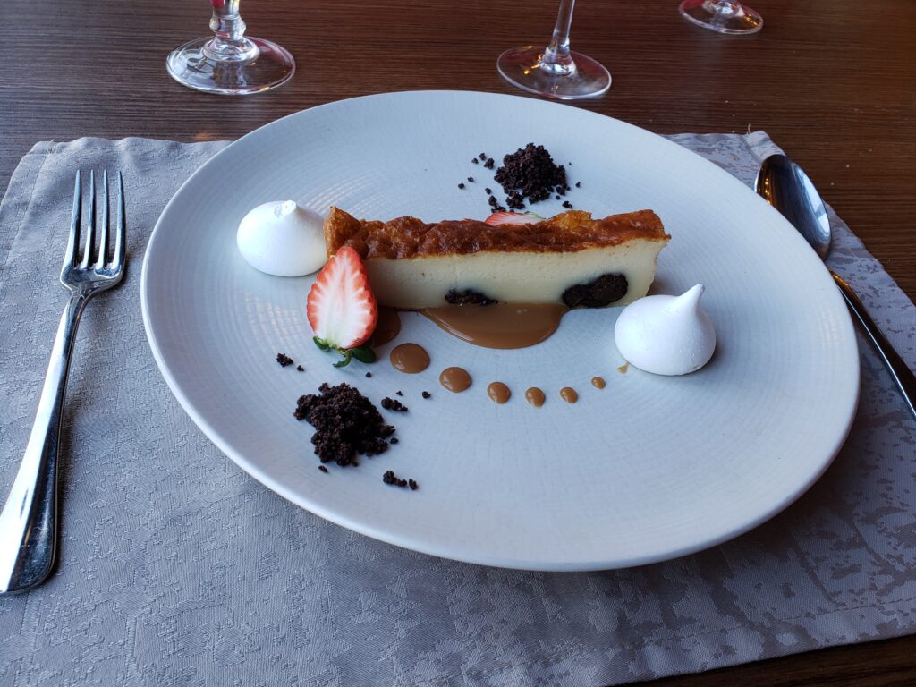A plate with a slice of Far Breton - a flan-like dessert - decorated with salted butter caramel.